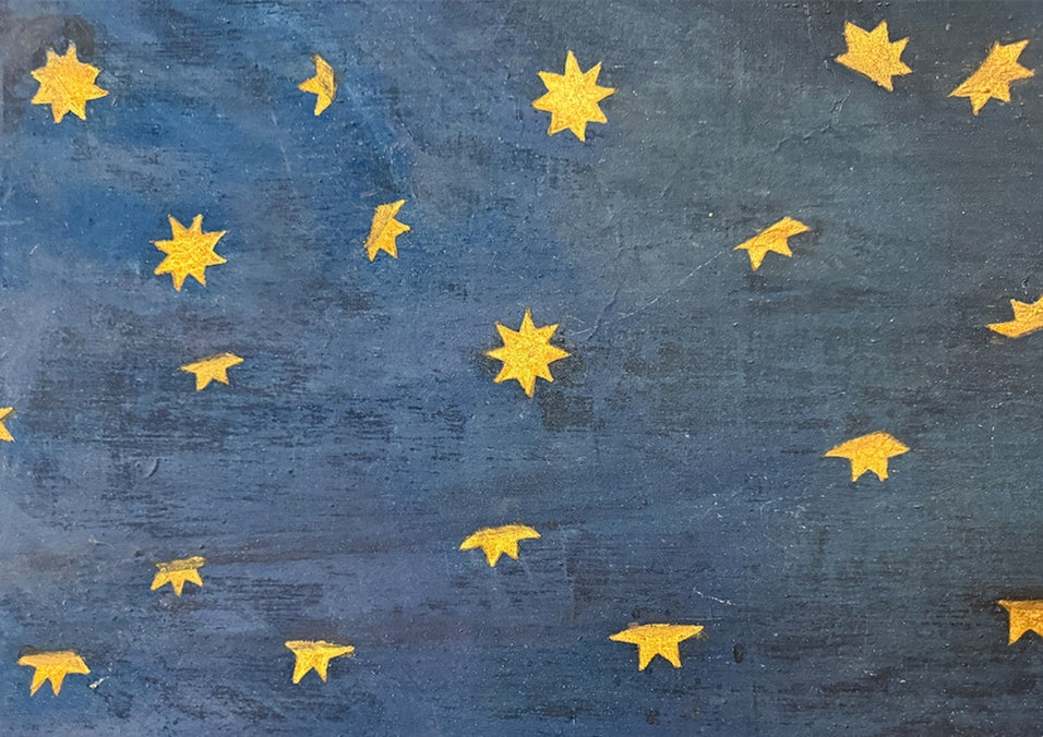 Golden stars on a textured blue surface, photographed  by Colette Falchet, in Rome, Italy.